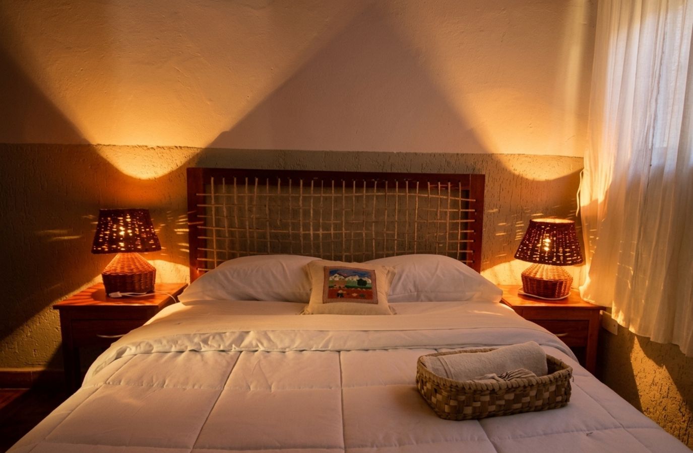 Room with warm light and wicker bedside lamps